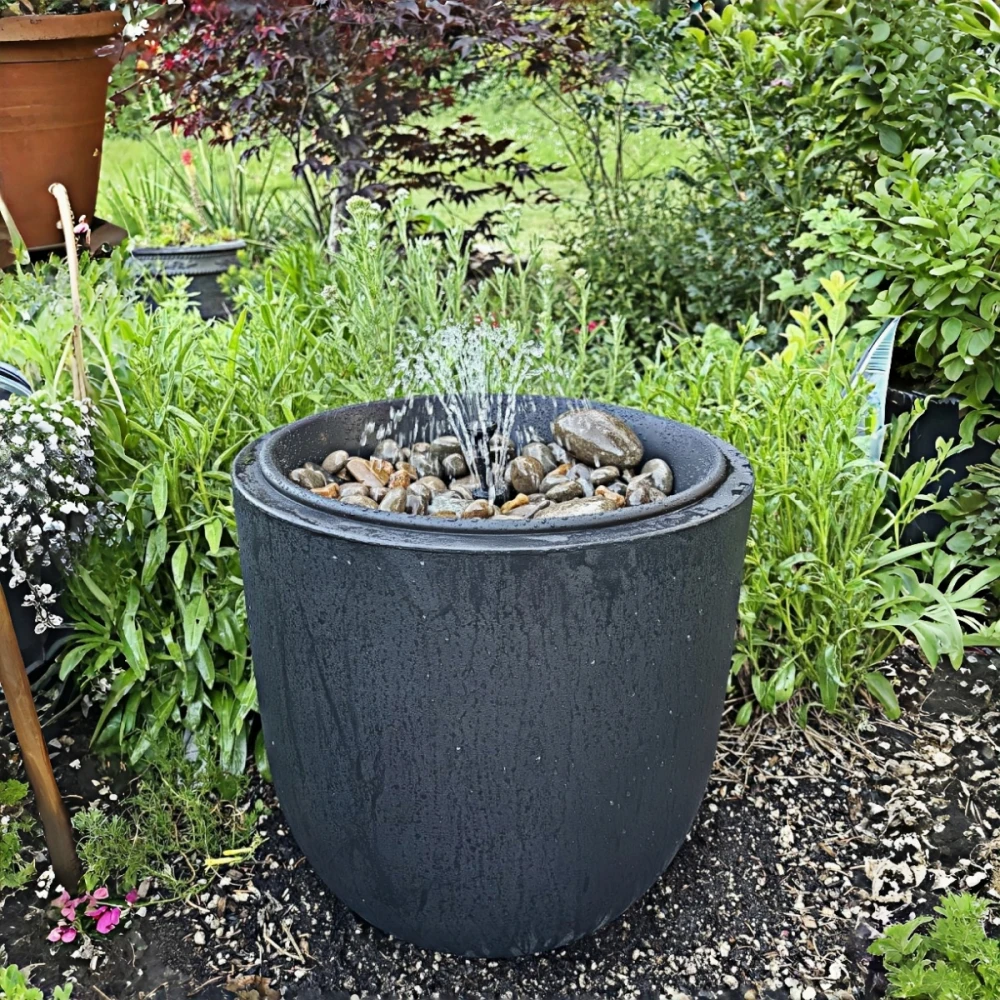 Decorative patio fountain in a container garden setup