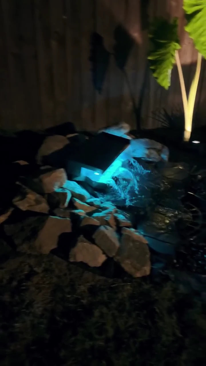 The finished waterfall at night with aqua lighting.